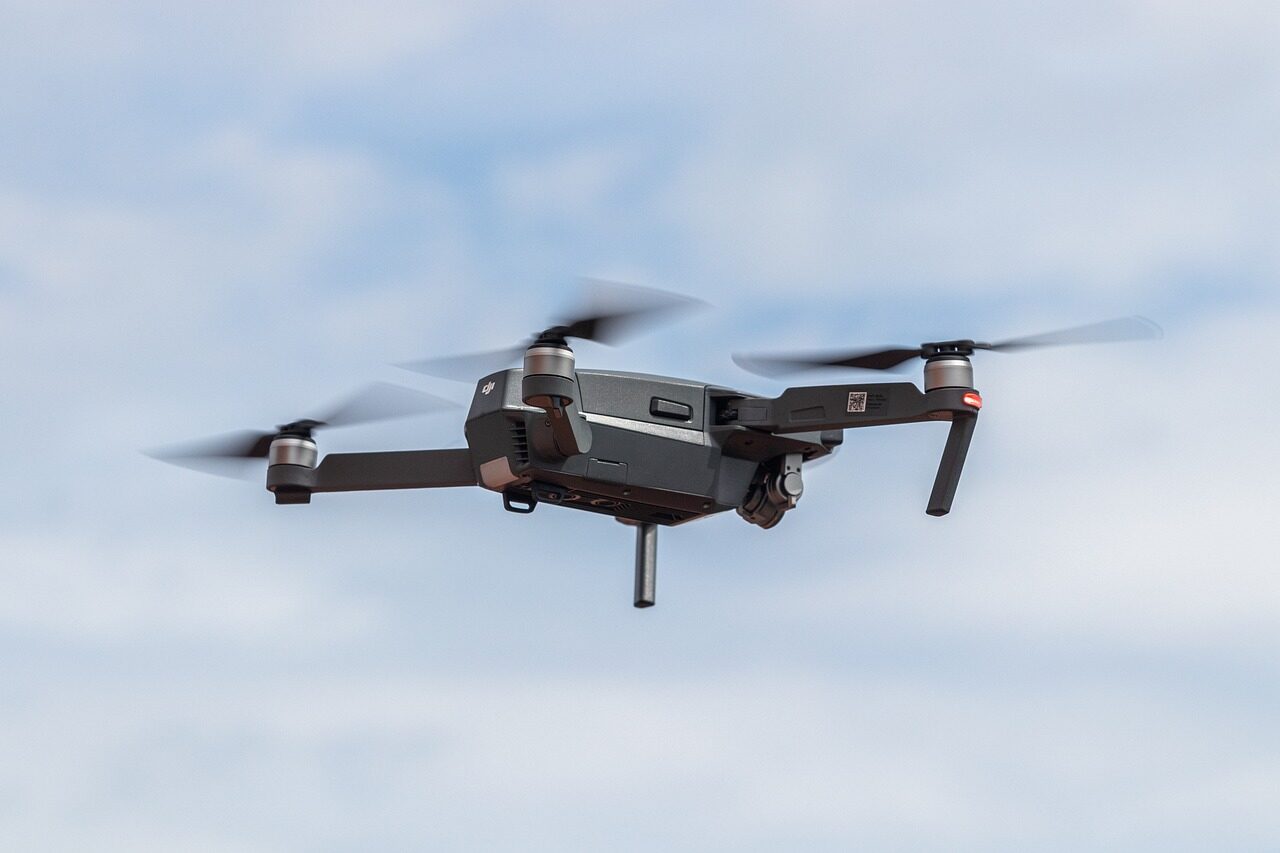 Ground crew conducting pre-flight checks on a strike-configured drone inside a field shelter.