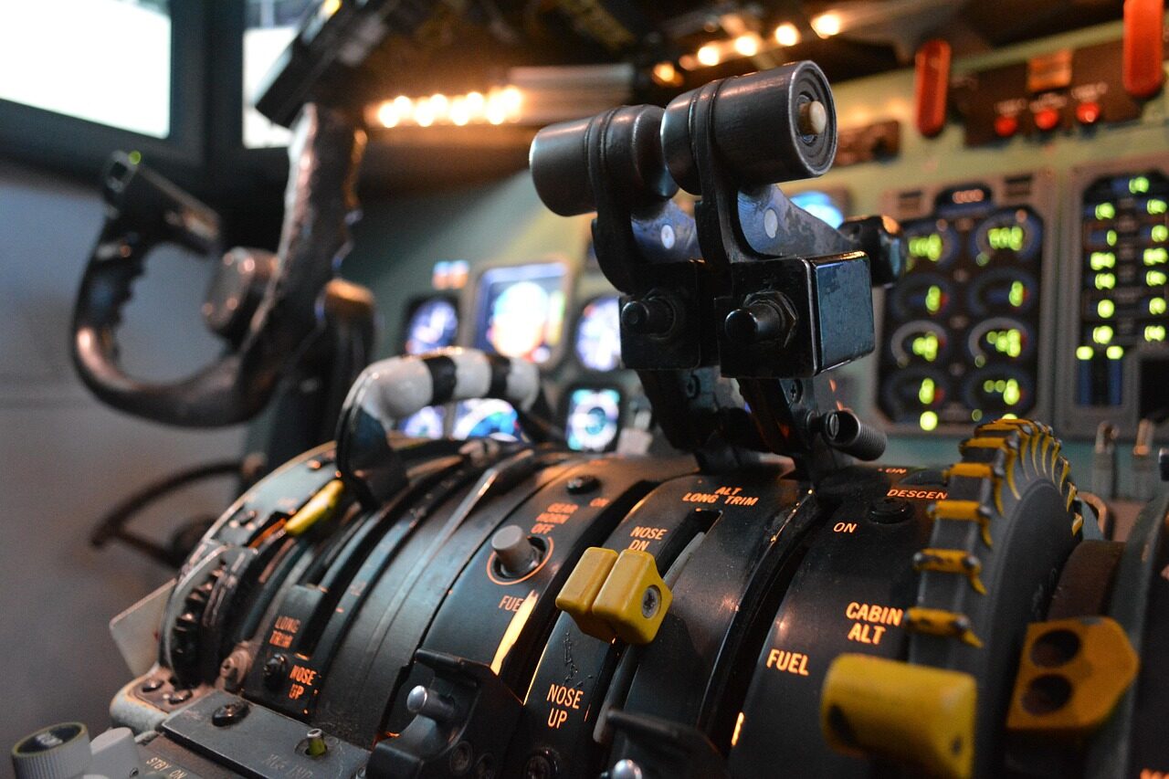 An operator wearing a VR headset flying a simulated mission at a training workstation.