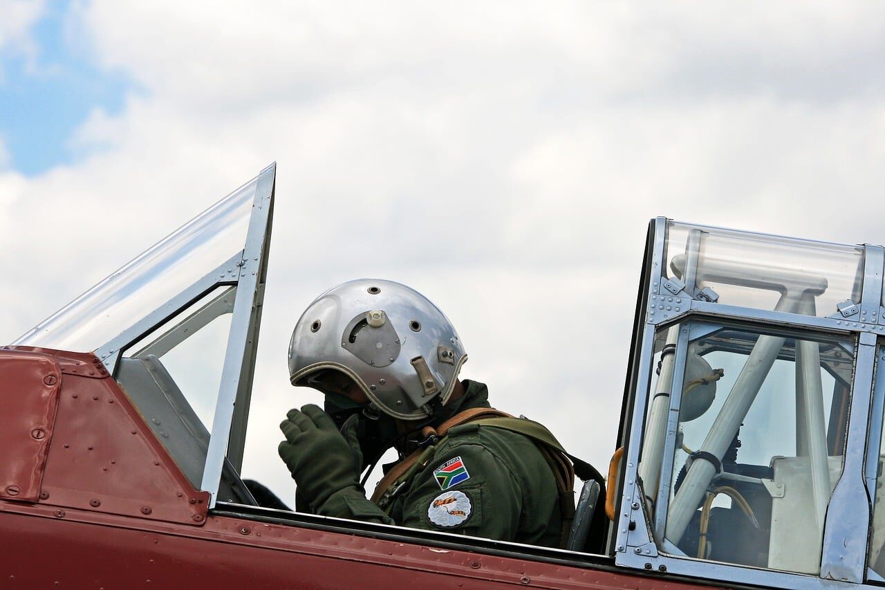 Instructors reviewing a trainee's simulated sortie replay on a large debrief screen.
