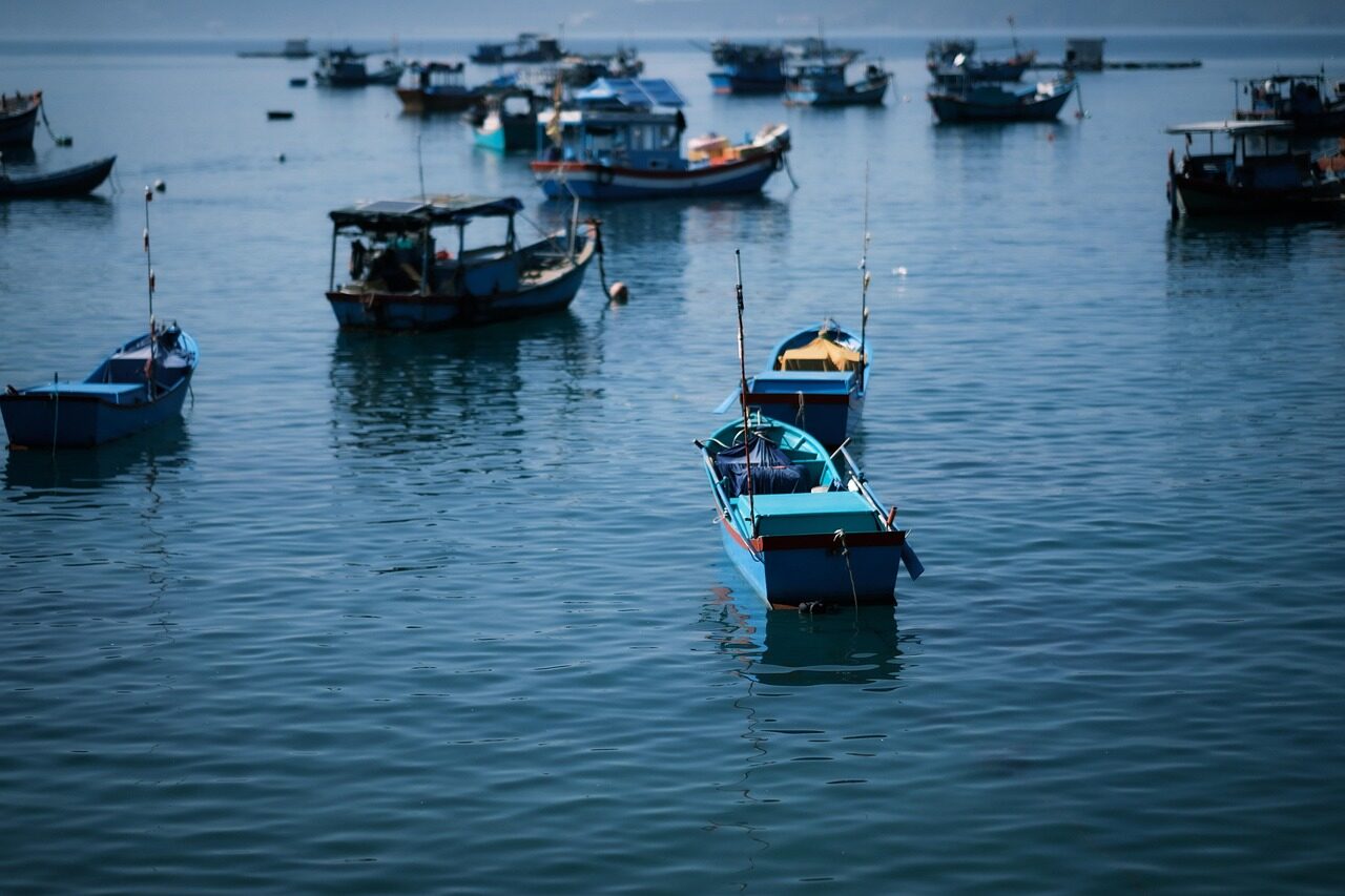 Small fishing fleet setting out at dawn toward advisory-marked productive waters.