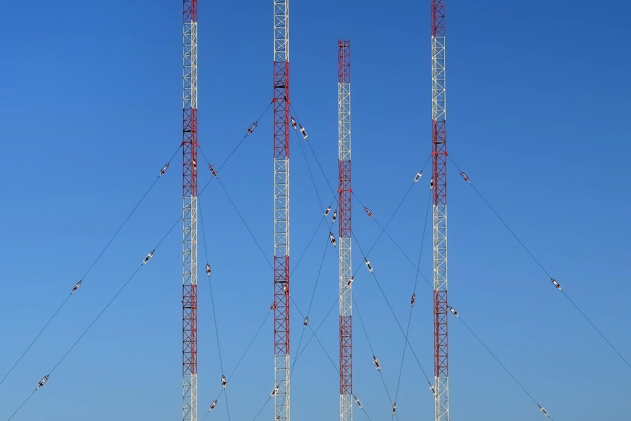 A vehicle-mounted mesh network terminal with antennas against a field-exercise backdrop.