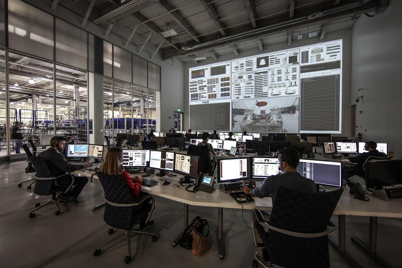 Operators managing a satellite fleet from a mission-control software workstation.