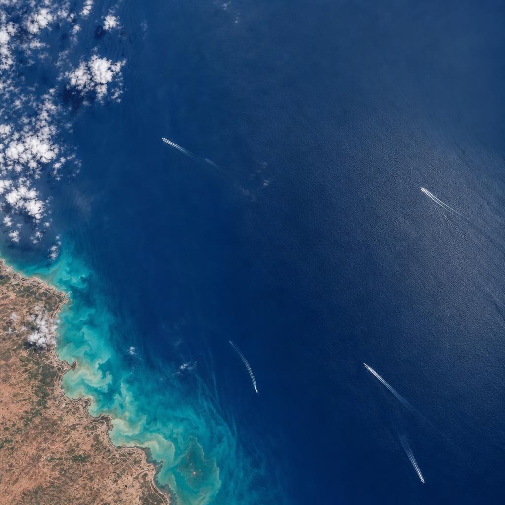 Patrol vessel underway at sea, cued toward a contact beyond the coastal radar horizon.